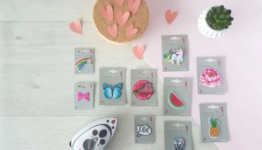 Un fer à repasser et divers patchs thermocollants : étoile filante, papillon, basket, pastèque, licorne, fleur, ananas, crâne, et bulle "Je rêve". Idéal pour créer un patch thermocollant personnalisé.