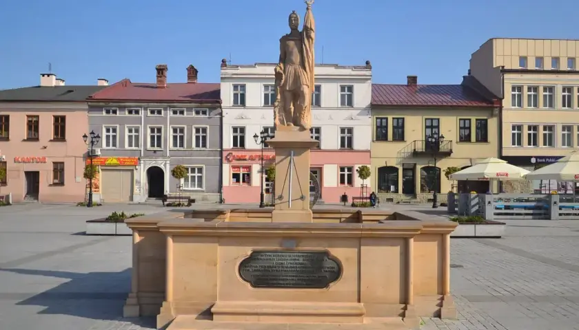 Pomnik na żywiec rynku, z kolorowymi kamienicami w tle.