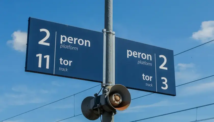 Niebieskie znaki na stacji kolejowej wskazują peron 2, tor 11 oraz peron 2, tor 3.