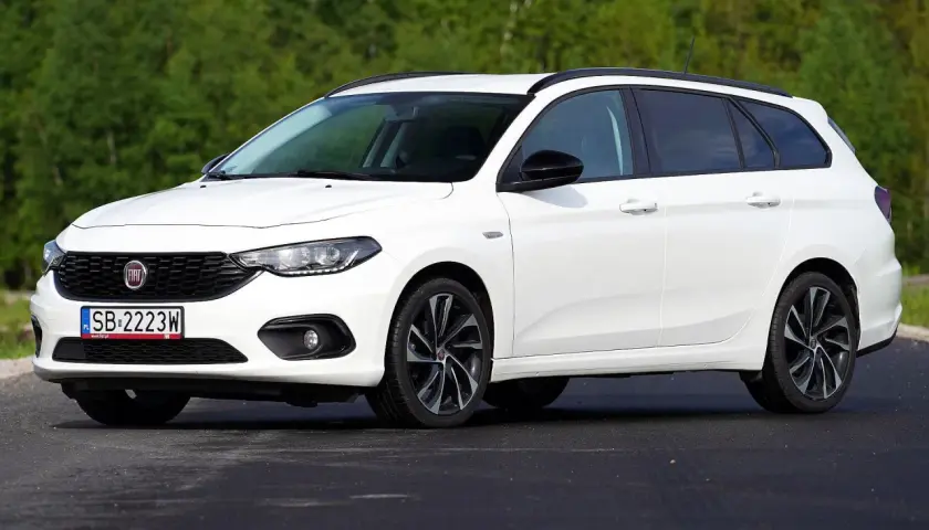 Biały Fiat Tipo kombi na tle zieleni. Wiele osób szuka takich aut, sprawdzając fiat tipo opinie.