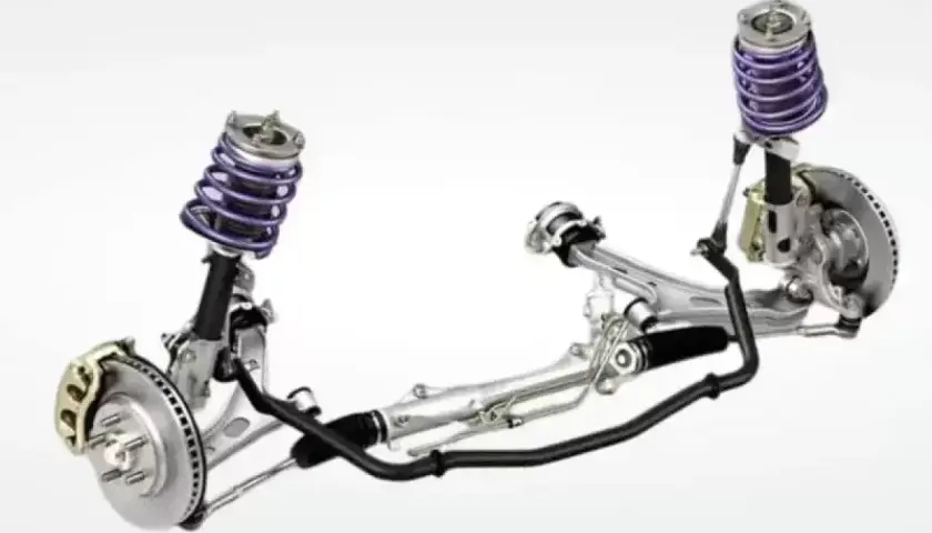Sistema de suspensión automotriz con amortiguadores morados, frenos de disco y una barra estabilizadora negra que conecta ambos lados.