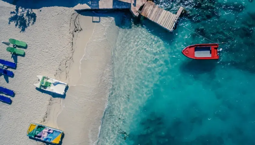 Idealne miejsce, gdzie w styczniu na wakacje: pusta plaża, łodzie czekają na wodzie, a słońce grzeje.