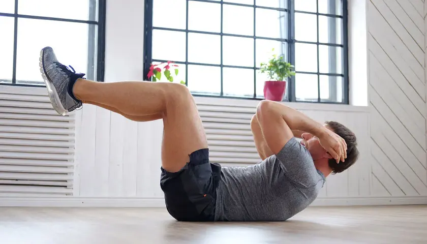 Hombre haciendo abdominales, parte de una rutina de ejercicios para bajar barriga.