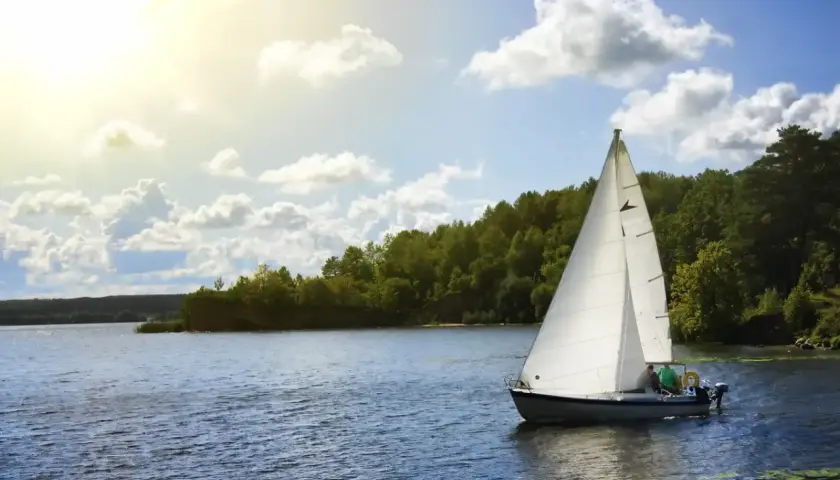 Ahoj Mazury! Biały żagiel na błękitnej wodzie, słońce i zielone brzegi. Idealny dzień na Mazurach.