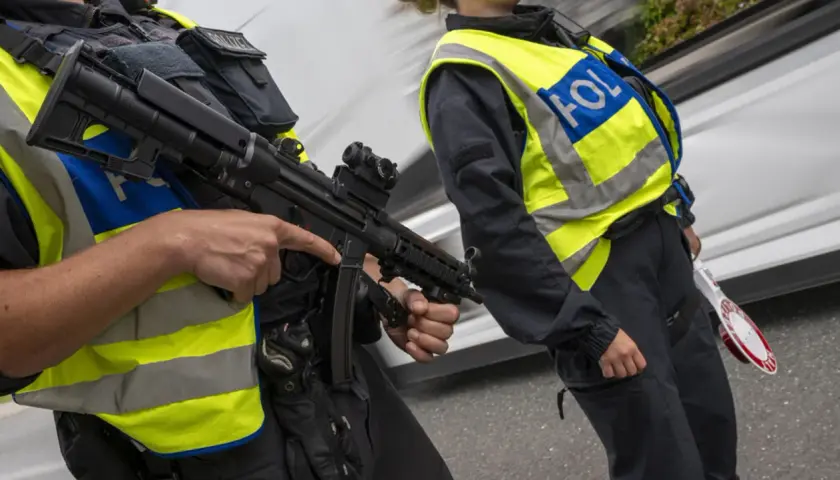 Zwei Polizisten mit Maschinenpistolen und Warnwesten führen Grenzkontrollen in Italien durch.