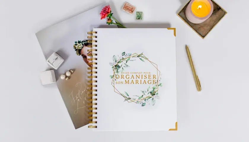 Guide complet pour organiser son mariage, avec bague, boucles d'oreilles, fleur et bougie.