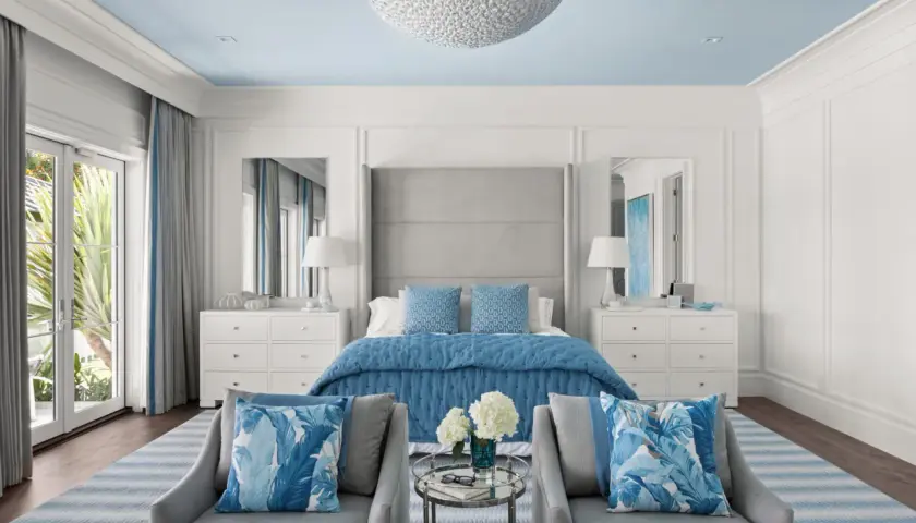 Serene master bedroom layout ideas with a blue and white palette, featuring a plush bed, mirrored nightstands, and comfortable seating.