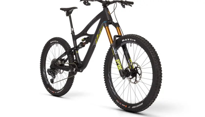 A black Ibis HD5 mountain bike with gold Fox suspension forks and Maxxis tires, ready for any trail.