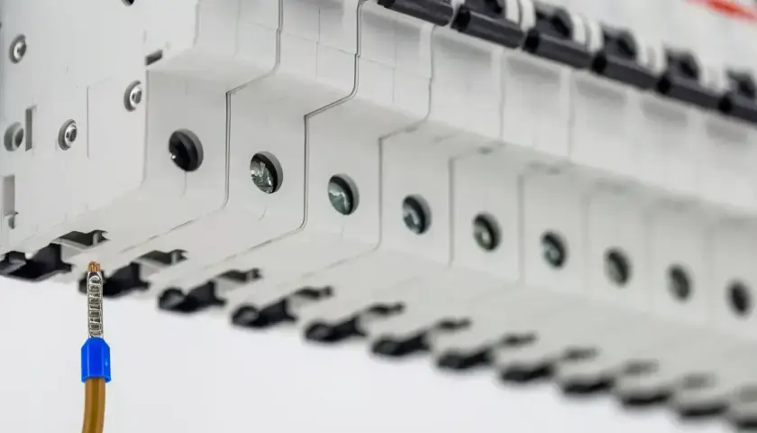 Szczegółowy widok bezpieczników w rozdzielnicy. Zbliżenie na przewód uziemiający. To ważny element koszt instalacji elektrycznej.