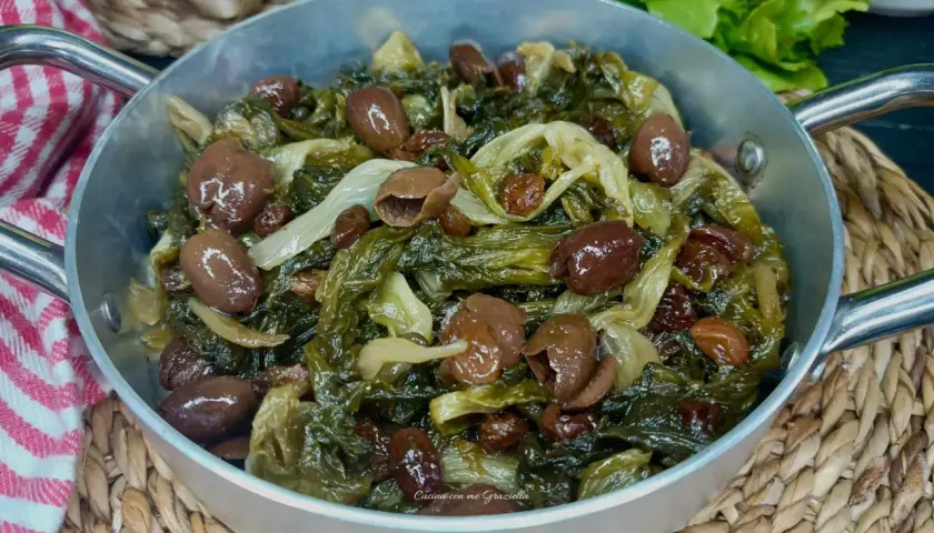 Scarola in padella con olive e uvetta, un contorno saporito e colorato, pronto per essere gustato.