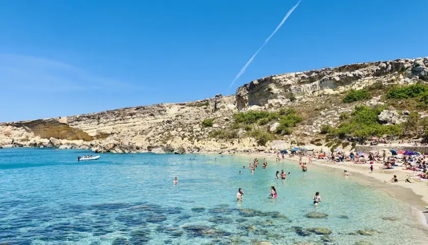 Słoneczny dzień w Paradise Bay na Malcie. Turkusowa woda, piaszczysta plaża i skaliste klify tworzą idylliczny krajobraz.