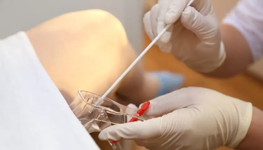 Prelievo per screening streptococco in gravidanza. Guanti medici e tampone per esame.