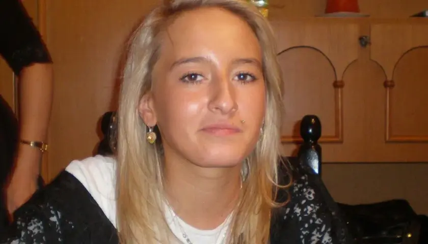 Młoda kobieta z blond włosami, kolczykiem w wardze i serduszkiem w uchu. Jej twarz jest w centrum uwagi, a w tle widać fragmenty mebli. Sprawa Iwony Wieczorek wciąż budzi emocje.