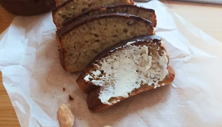 Pyszny chlebek bananowy z airfryera, pokrojony w plastry, jeden posmarowany masłem. Idealny na śniadanie.