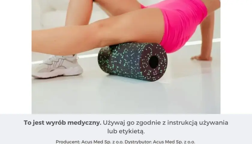 Kobieta wykonuje rolowanie mięśni ud za pomocą czarnego wałka z zielonymi kropkami.