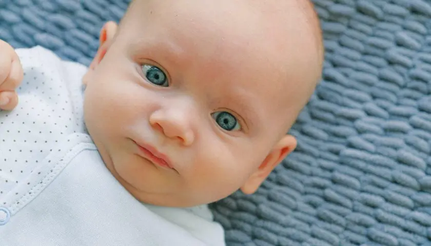 Occhi di un neonato di un blu intenso, quasi neon, che catturano lo sguardo.