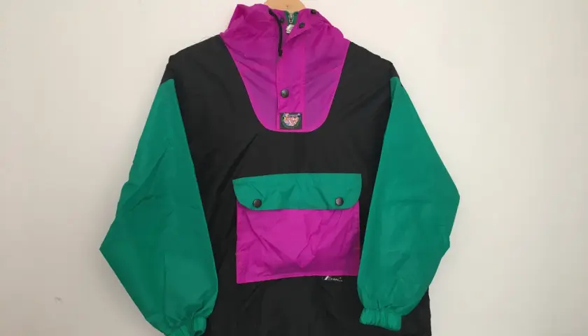 Coupe-vent K-Way noir, rose vif et vert, à capuche et poche kangourou.