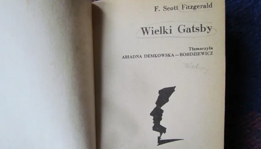 Strona tytułowa "Wielkiego Gatsby'ego" F. Scotta Fitzgeralda. Czarno-biała grafika profilu twarzy.