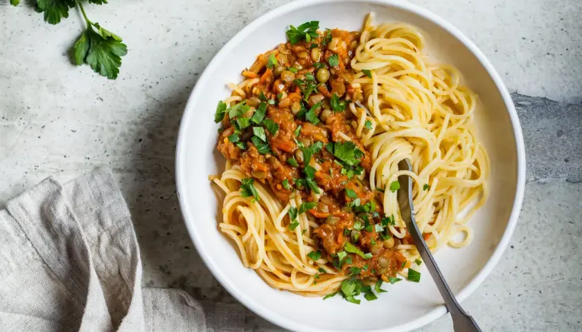 Spaghetti z sosem z soczewicy i warzyw, posypane natką. Idealne, gdy zastanawiasz się, jaki ser do spaghetti zamiast parmezanu.