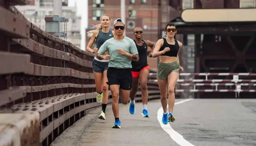 Grupa biegaczy na moście, wykonująca trening fartlek. Dynamiczne tempo i skupienie na osiągnięciu celu.