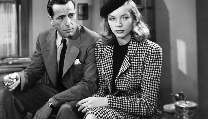 Humphrey Bogart och Lauren Bacall i "The Big Sleep". Hon bär en rutig dräkt och basker, han en kostym och slips.