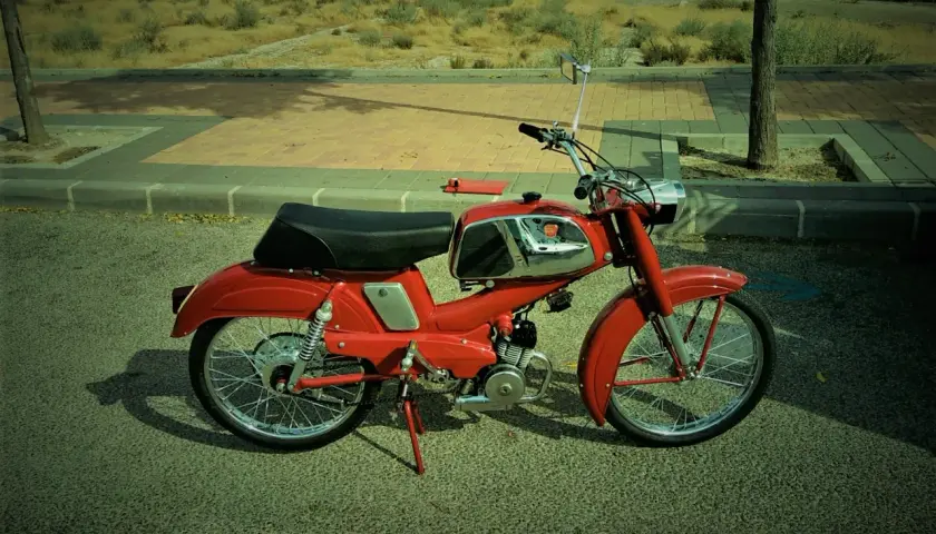 Ciclomotor rojo antiguo, listo para pasar la itv. Un clásico que evoca tiempos pasados.