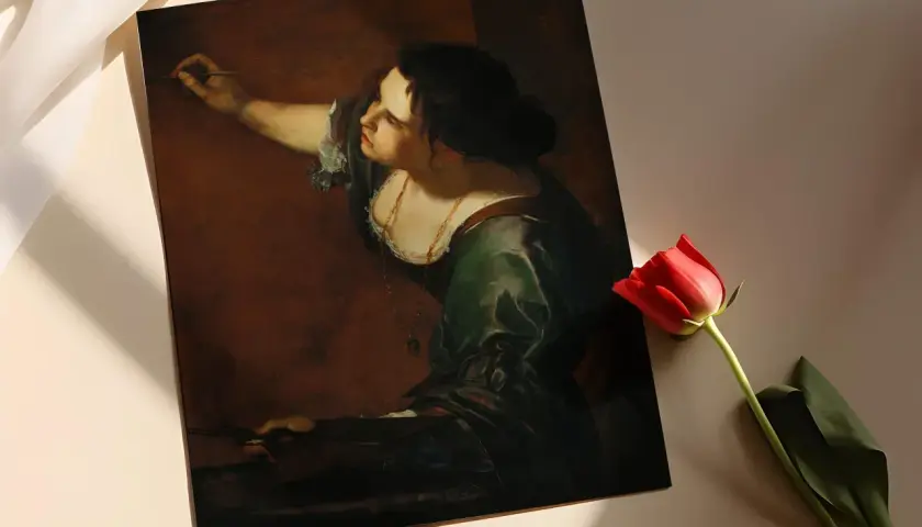 Obraz przedstawia kobietę malującą obraz, co jest doskonałym przykładem konceptyzmu w sztuce. Czerwona róża dodaje głębi.