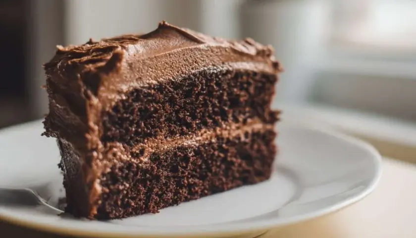Une part généreuse de cake au chocolat, avec un glaçage onctueux et une texture moelleuse. Un délice pour les amateurs de chocolat.