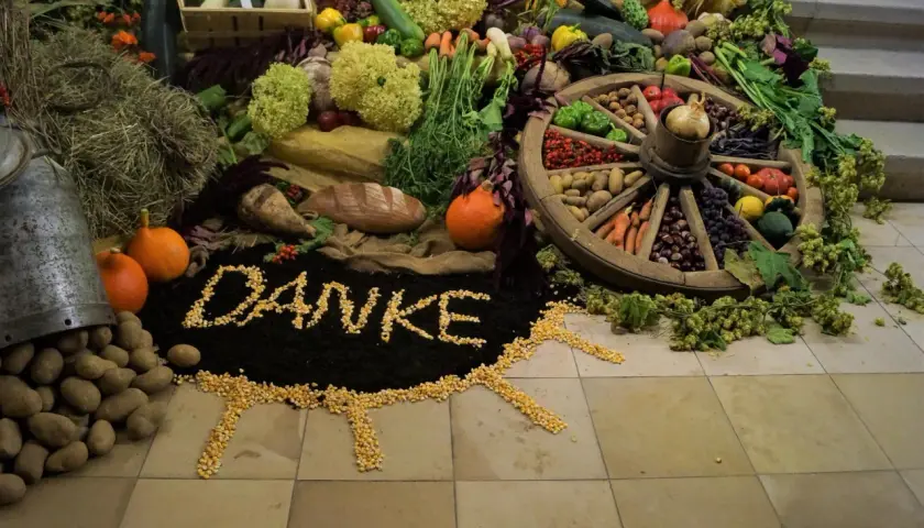 Ein liebevoll gestalteter Erntedankaltar mit Gemüse, Früchten, Brot und dem Wort "Danke" aus Mais.