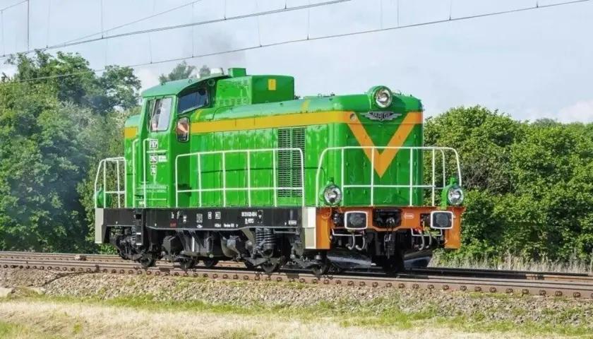 Zielona lokomotywa **Fablok 6D** z żółtym pasem i literami "PKP" na tle zieleni.
