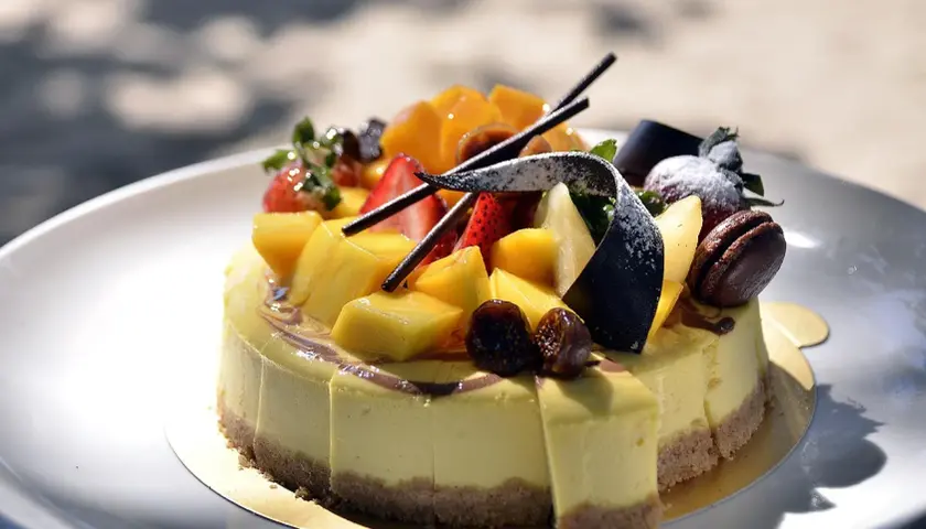 Jak udekorować tort dla chłopca? Kolorowy tort z mango, truskawkami i czekoladą, idealny na przyjęcie.