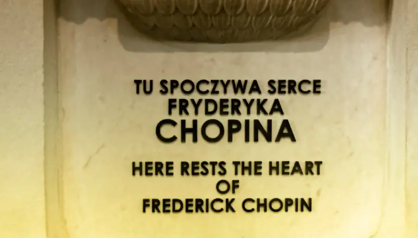 Tu spoczywa serce Chopina. Napis na pomniku upamiętniającym miejsce pochówku serca Fryderyka Chopina.