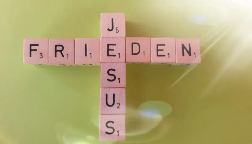 Frieden lasse ich euch, meinen Frieden gebe ich euch. Johannes 14,27. Holzbuchstaben bilden ein Kreuz mit den Wörtern FRIEDEN und JESUS.