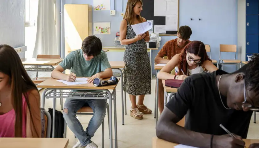 Des élèves concentrés passent un examen en classe, peut-être pour une bourse college.
