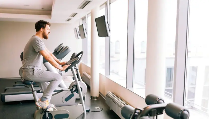 Mężczyzna ćwiczy na rowerze stacjonarnym, który może być dobrym wyborem, jeśli zastanawiasz się, jaki rower stacjonarny do rehabilitacji kolana wybrać.