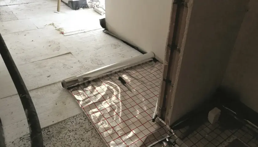 Przygotowania do wylewania posadzki z ogrzewaniem podłogowym. Folia izolacyjna z siatką.