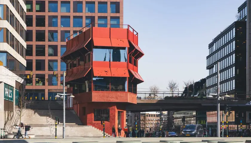 Rött, unikt hus vid Sergels torg, med trappor och moderna byggnader runtom. En plats för bio och möten.