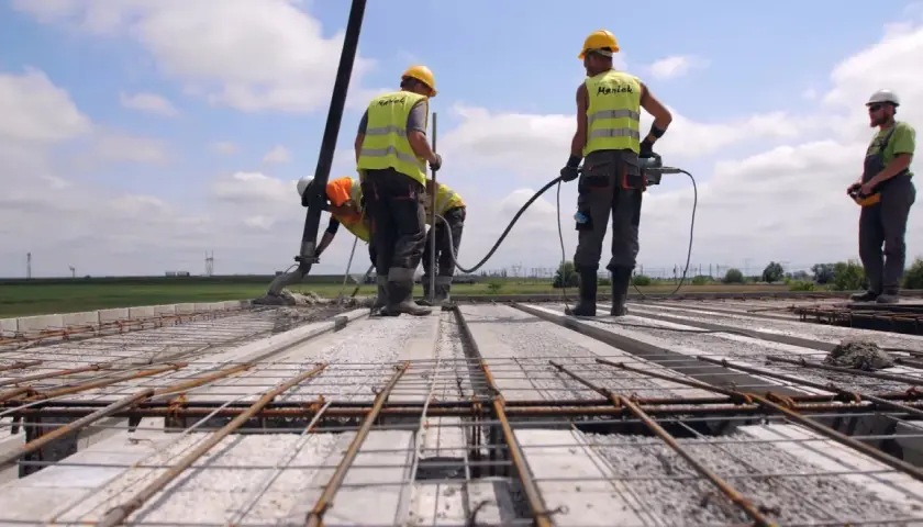 Budowa stropu: pracownicy wylewają beton, używając pompy. Jaki beton na strop? Ten, który zapewni trwałość konstrukcji.