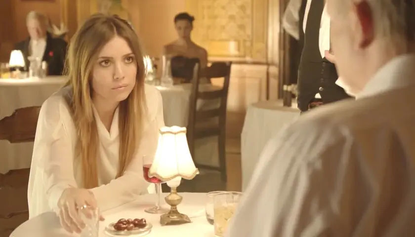 Lykke Li w białej bluzce, zamyślona przy stoliku. Czyżby "sadness is a blessing"?