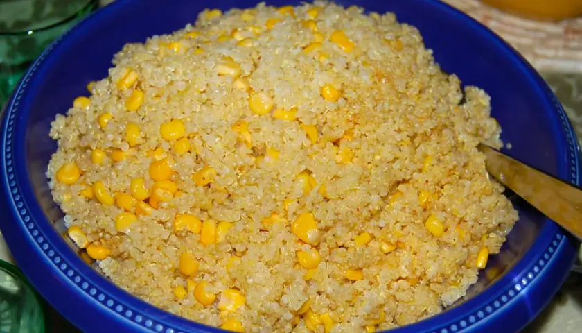 En blå skål fylld med fluffig quinoa och söta majskorn. Perfekt för att koka quinoa till en hälsosam måltid.