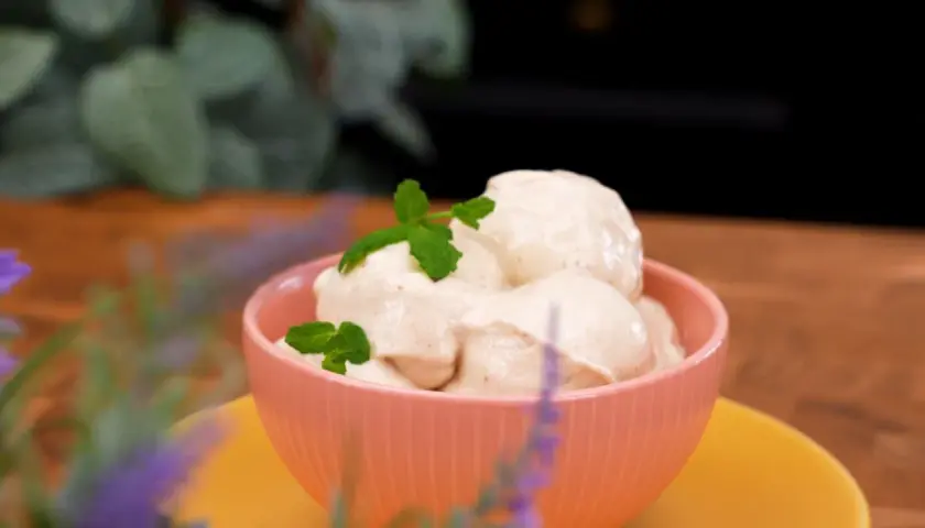 En skål med krämig, nyttig glass toppad med myntablad. En härlig sommardessert som passar alla.