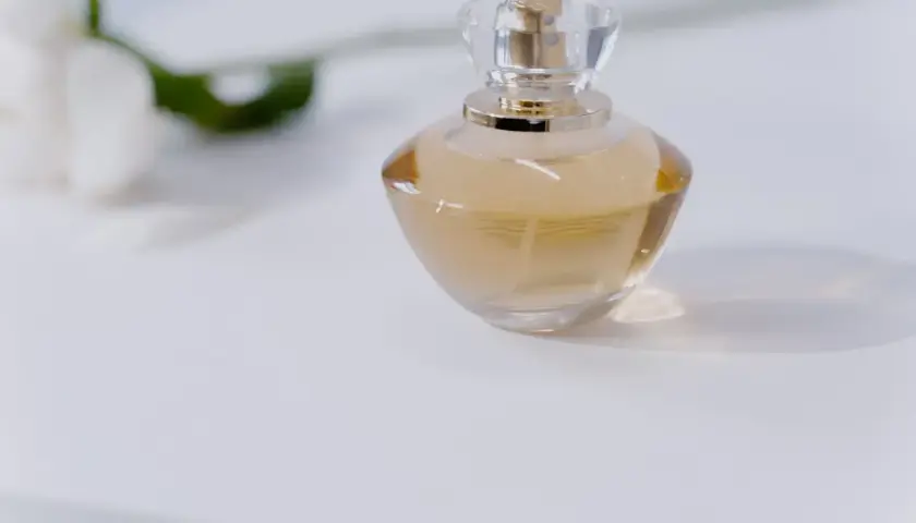 Elegancka butelka perfum na białym tle. Dowiedz się, jak sprawdzić oryginalność perfum, by cieszyć się ich unikalnym zapachem.