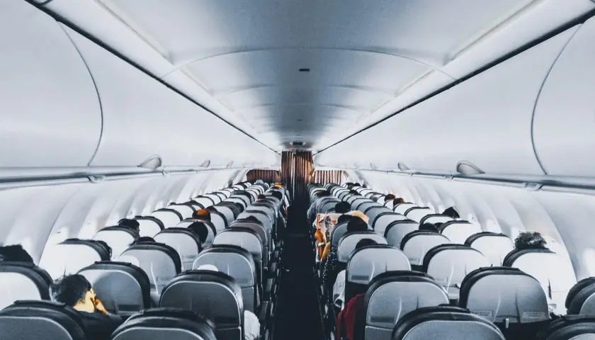 Wnętrze samolotu Wizz Air, rzędy siedzeń wypełnione pasażerami. Wizz Priority zapewnia komfortową podróż.