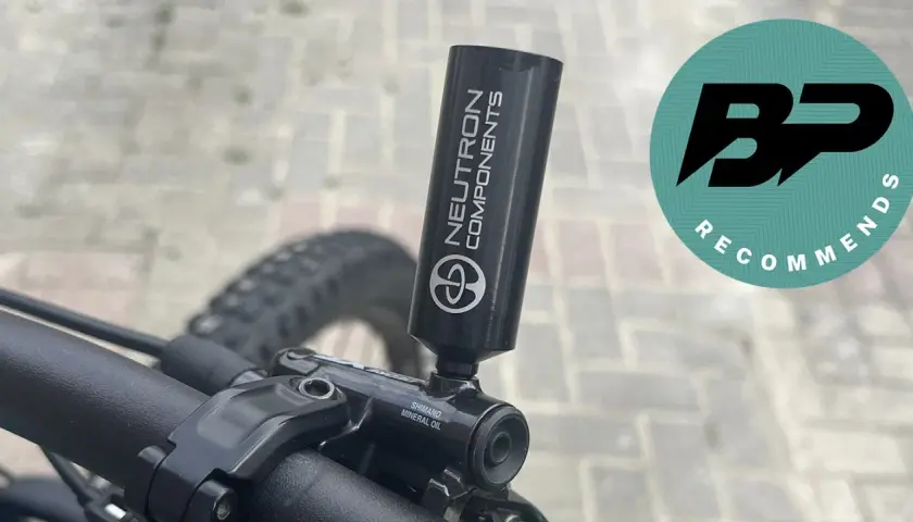 Close-up of a bicycle's mineral oil brake system with a "Neutron Components" tool attached.