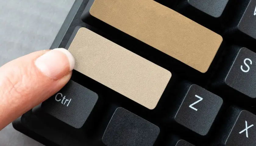 Palec naciska na klawisz Ctrl, obok pustych, beżowych klawiszy na klawiaturze. To idealne miejsce na Twój lnk!