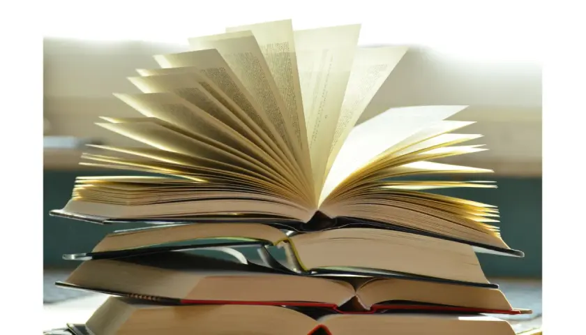 Pile de livres ouverts, pages déployées comme un éventail, évoquant la richesse du savoir et la quête spirituelle. Une maison d'édition spiritualité qui ouvre les portes de la connaissance.