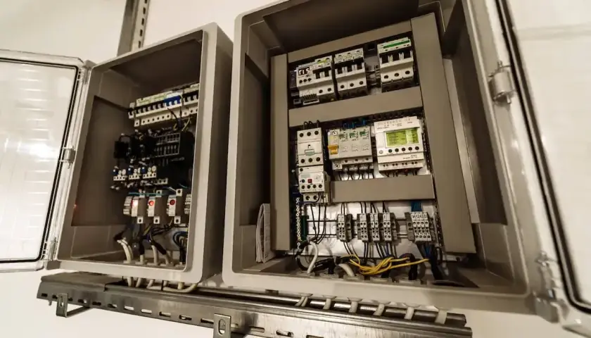 Przeniesienie skrzynki elektrycznej zakończone sukcesem. Widać wnętrze z bezpiecznikami, przekaźnikami i okablowaniem.