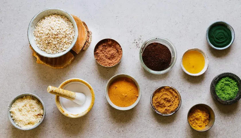 Ingredienser för en hemmagjord hårbottenskrubb: havre, kakao, kaffe, gurkmeja, spirulina och olja.
