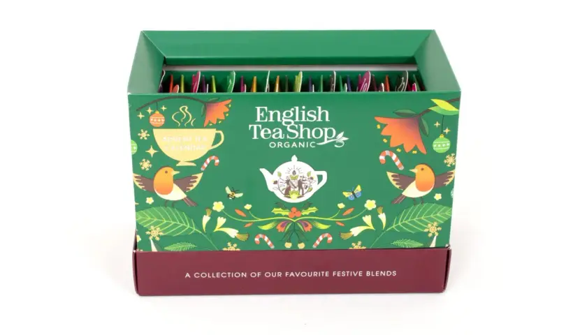 Zielony kalendarz adwentowy English Tea Shop z motywami świątecznymi, ptaszkami i liśćmi. W środku rzędy paczuszek z herbatą.