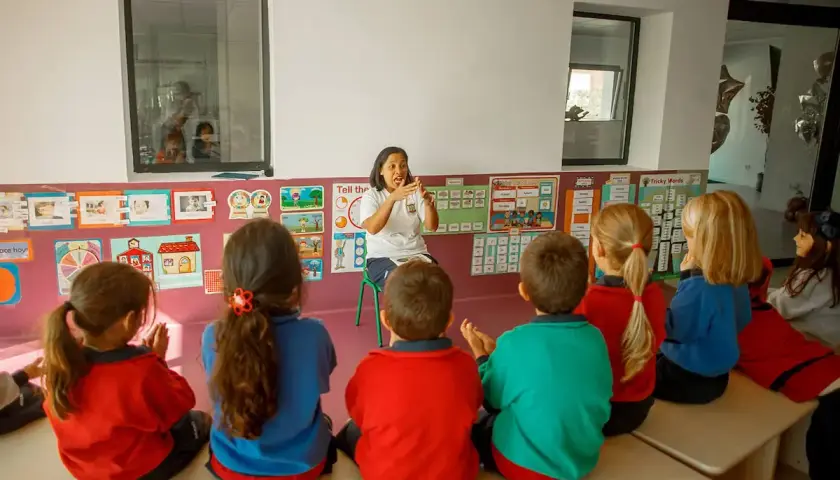 Niños atentos en una guardería o escuela infantil, escuchando atentamente a su maestra.
